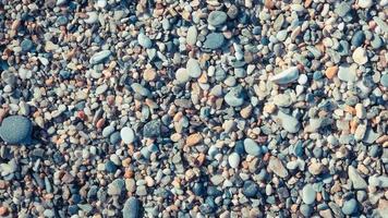 spiaggia pietre superficie ciclo continuo. marino minerale bellezza armonia. mare ciottolo struttura. video