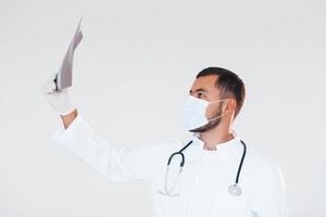 médico con rayos x. joven apuesto hombre de pie en el interior contra el fondo blanco foto