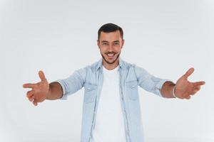 Young handsome man standing indoors against white background photo