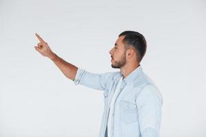 Young handsome man standing indoors against white background photo