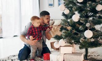 padre con su hijo pequeño celebra el año nuevo y la navidad juntos foto