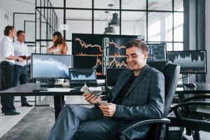 Ordinary office day. Team of stockbrokers works in indoors with many display screens photo