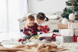 Little brother with her daughter celebrates New year and christmas at home photo