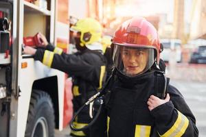 Group of firefighters in protective uniform that outdoors near truck photo