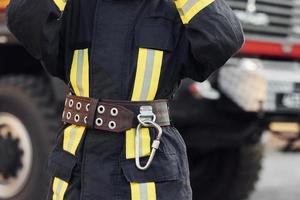 Female firefighter in protective uniform standing near truck photo