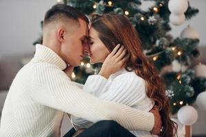 cercanía de la gente. joven pareja romántica celebra el año nuevo juntos en el interior foto