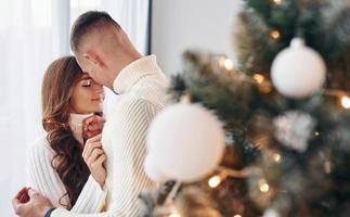 Closeness of the people. Young romantic couple celebrates New year together indoors photo