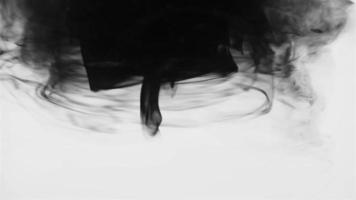 Black ink in swirling motion on a white background video