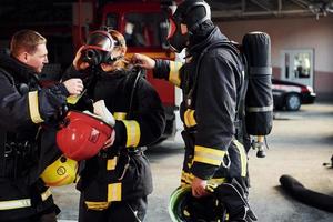 grupo de bomberos con uniforme protector que está en la estación foto