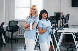 grupo de trabajadores limpian la oficina moderna juntos durante el día foto