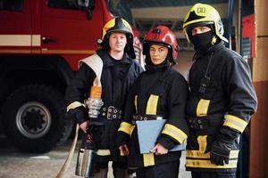 Posing for a camera. Group of firefighters in protective uniform that is on station photo