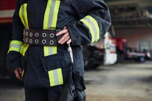 Close up view. Female firefighter in protective uniform standing near truck photo