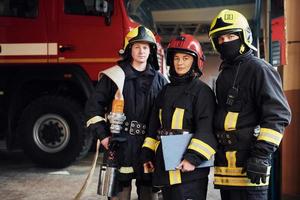 Posing for a camera. Group of firefighters in protective uniform that is on station photo