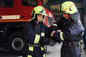 Male and female firefighters in protective uniform standing together photo