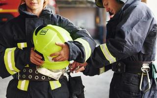 Male and female firefighters in protective uniform standing together photo