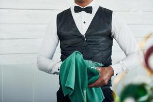 Black waiter in formal clothes is at his work outdoors at sunny daytime photo