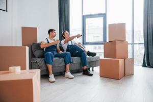 Two young movers in blue uniform working indoors in the room photo