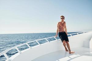 joven turista masculino está en el yate en el mar. concepto de vacaciones foto