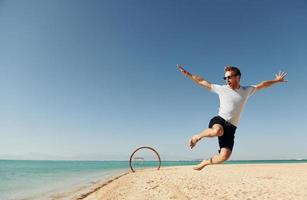 Having fun. Young european man have vacation and enjoying free time on the beach of sea photo