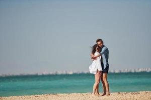 Young european couple have vacation together on the sea at sunny daytime photo