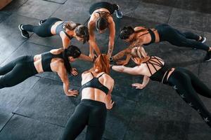 Plank exercise. Group of young sportive people have crossfit day indoors in gym photo