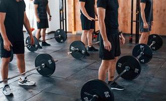 Group of young sportive people have crossfit day indoors in gym photo