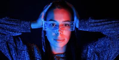 Portrait of young girl that is in eyeglasses in blue neon lighting photo