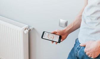 Close up view of man that is indoors controlling smart home technology photo