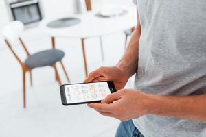 Close up view of man that is indoors controlling smart home technology photo