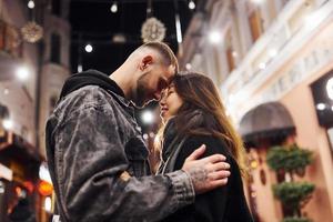 feliz pareja multirracial juntos al aire libre en la ciudad celebrando el año nuevo foto