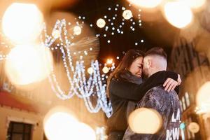 feliz pareja multirracial juntos al aire libre en la ciudad celebrando el año nuevo foto