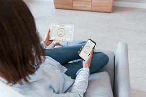 Modern technologies. Rear view of woman that is indoors controlling smart home photo