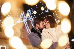 feliz pareja joven celebrando el año nuevo al aire libre en la calle foto