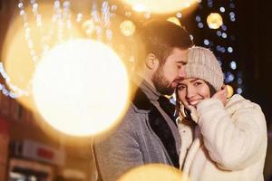 Closeness of the people. Happy young couple celebrating New year outdoors on the street photo