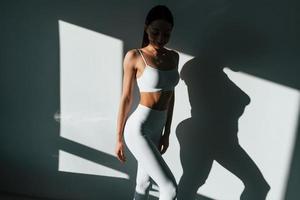 Beautiful lighting. Young caucasian woman with slim body shape is indoors at daytime photo