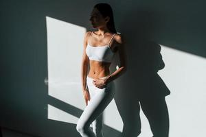 Beautiful lighting. Young caucasian woman with slim body shape is indoors at daytime photo