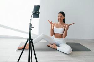 el teléfono está grabando video. joven mujer caucásica con forma de cuerpo delgado está en el interior durante el día foto