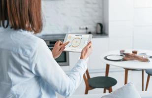 Modern technologies. Rear view of woman that is indoors controlling smart home photo