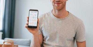 Close up view of man that is indoors controlling smart home technology photo