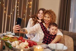 Happy family of mother, daughter and son is on the kitchen at evening time photo