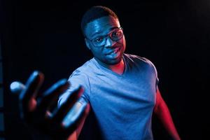 Futuristic neon lighting. Young african american man in the studio photo