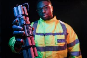 Policeman with bomb. Futuristic neon lighting. Young african american man in the studio photo
