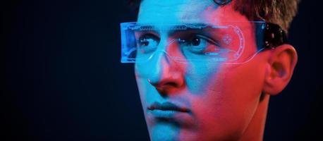 Close up portrait. Neon lighting. Young european man is in the dark studio photo