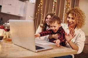 Cheerful people having happy weekend. Family of mother, daughter and son is on the kitchen at evening time photo