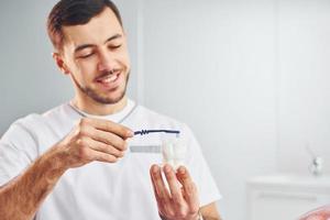 retrato de dentista profesional con equipo que se encuentra en el interior foto