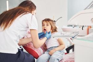 niña visitando al dentista en la clínica. concepción de la estomatología foto