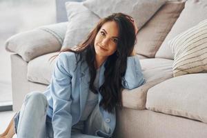 habitación doméstica. mujer europea en ropa elegante de moda está posando en el interior foto