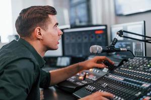 Young man is indoors in the radio studio is busy by broadcast photo