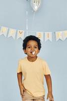 feliz niño afroamericano diviértete en el interior de la fiesta de cumpleaños foto