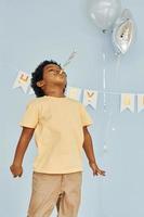 Happy little african american kid have fun indoors at birthday party photo